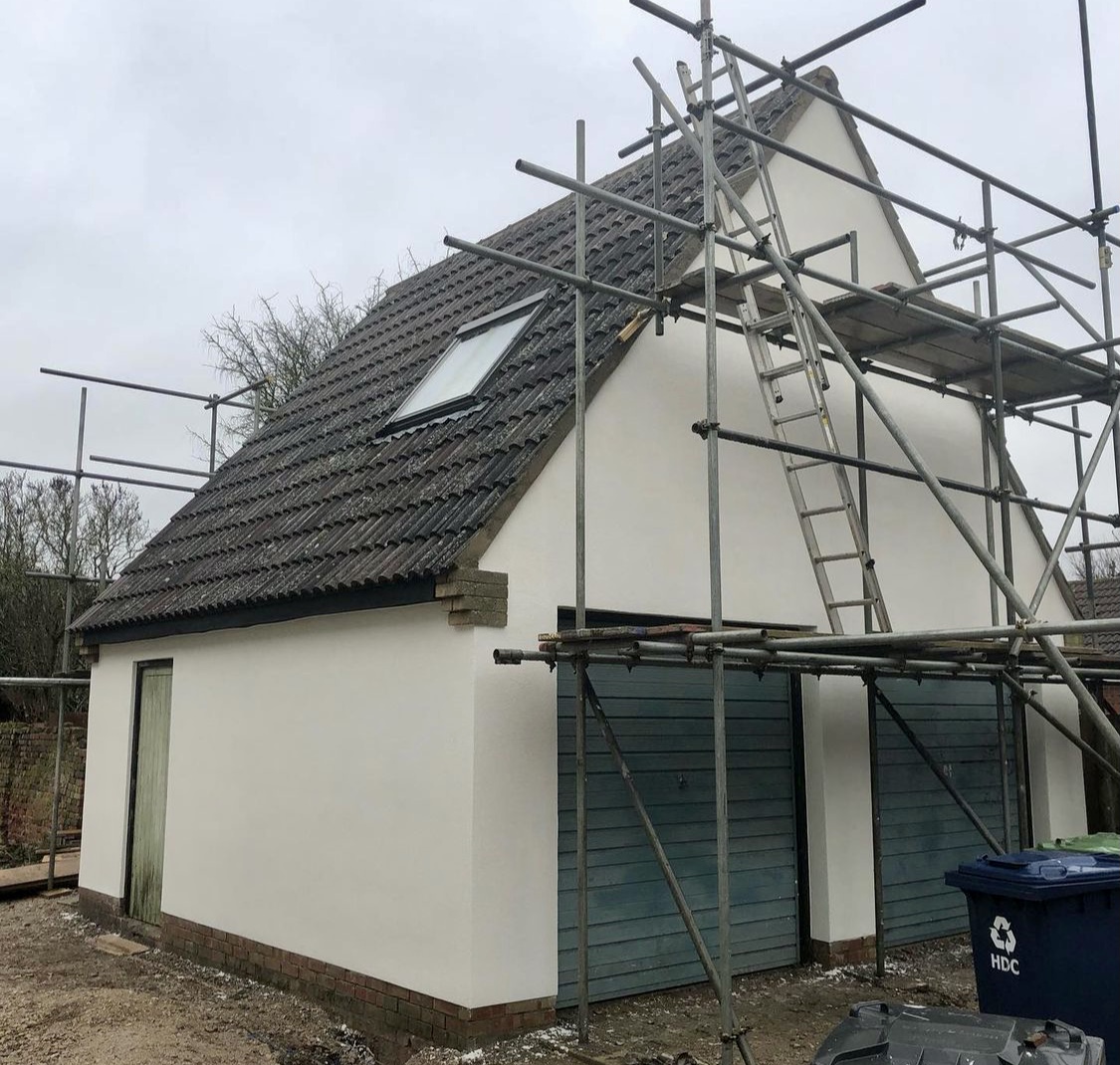 Chalet bungalow in white render with scaffolding still up
